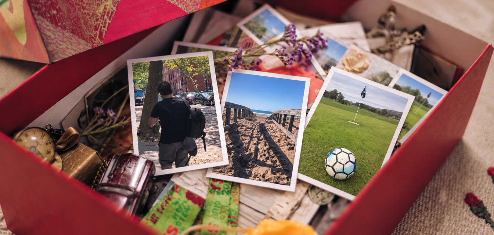 Una pequeña colección de fotos Pocket 7 por 10 dentro de una caja de recuerdos abierta.